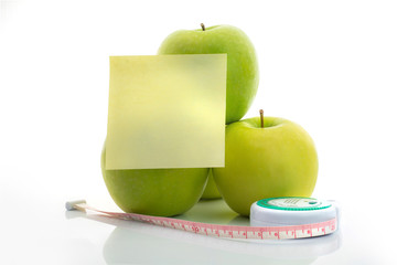 Measuring tape and green apple as a symbol of diet with note pap