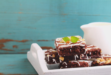 chocolate brownie cake with nuts and ising on a white tray
