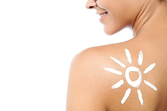 Woman with sunscreen lotion on her back