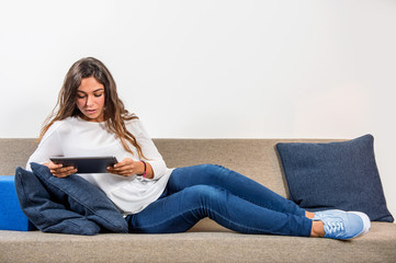 Young woman with electronic tablet on a couch