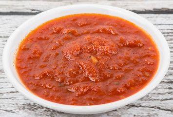 Spaghetti sauce in a white bowl over wooden background