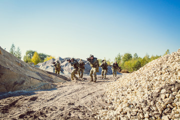 Obraz premium soldiers running across the field and shoot