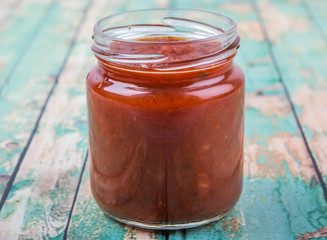 Spaghetti sauce in a mason jar over wooden background