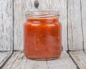 Spaghetti sauce in a mason jar over wooden background