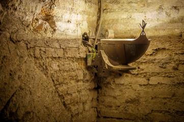 Old cript or basement textured wall with a brass lamp