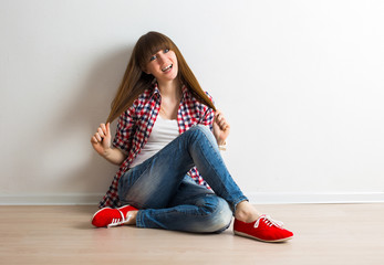 Beautiful young woman in modern casual clothing sitting on the f