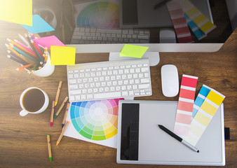Modern office workplace with digital tablet, notepad, colorful p