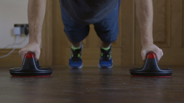Front facing view of a man doing press ups at home