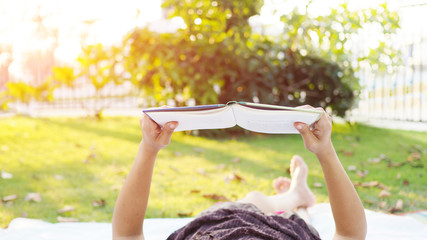 Asian woman reading book outdoor.