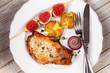 Grilled Pork Chop with Figs on Scewer, Crisp Roasted Potatoes and Thyme. View from above, top studio shot