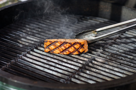 stages of cooking salmon on the grill - roasted piece of fillet on gridiron