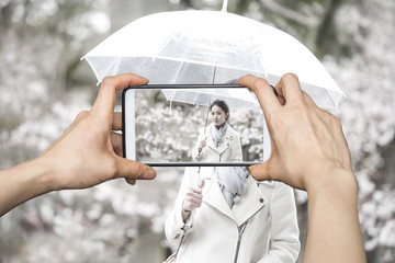 Taking pictures on mobile smart phone at Japanese woman