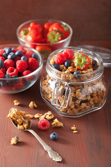homemade healthy granola in glass jar and berries