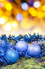 Xmas blue baubles on blurred yellow background