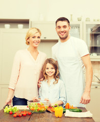 Obraz na płótnie Canvas happy family making dinner in kitchen