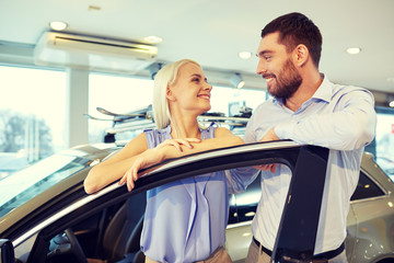 Obraz premium happy couple buying car in auto show or salon