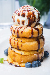 delicious dessert donuts with apples and ice cream on a white plate with decoration on a wooden table in a restaurant