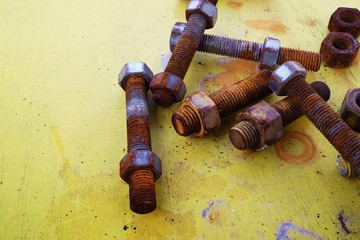 Closeup of rusty screw-nut on yellow wooden