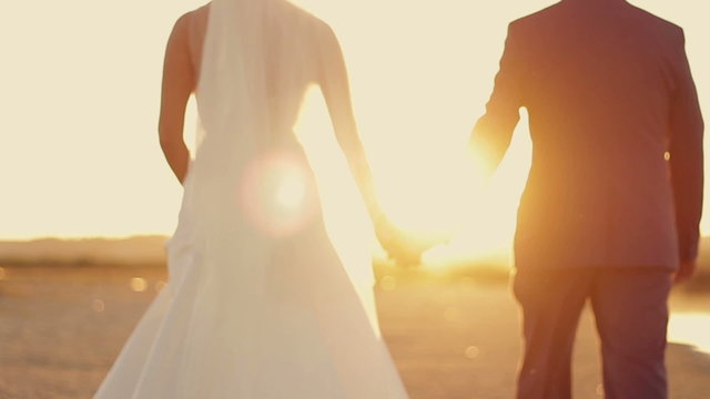 the  bride and groom are on the beach at sunset on the sand in the sun