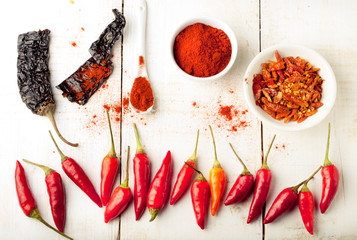 Chili peppers fresh and dry, smoked paprika. White wooden background. 