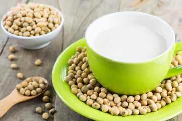 Soy milk [Soya milk ] in green cup and soy bean in wooden spoon