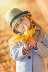 Beautiful colorful fun of a young girl in the autumn sunny day