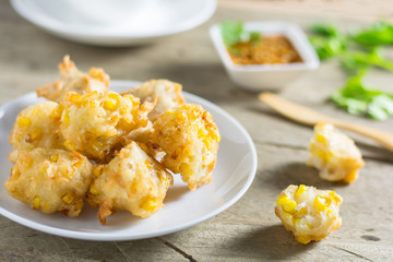 Crispy fried corn ball in a white plate on wooden table,Vegetari