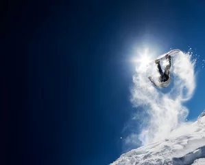 Tuinposter Snowboarder maakt hoogspringen in heldere blauwe lucht. Concept: plezier, sport, moed, avontuur, gevaar, extreem. Grote exemplaarruimte aan de linkerkant. © rcaucino