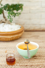 Obraz na płótnie Canvas Green tea in a ceramic bowl with honey.