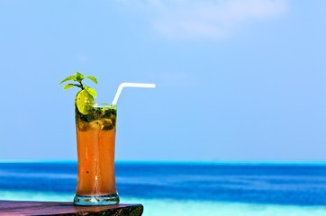 Glass of drink is on a beach table