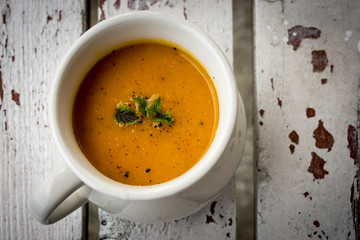 Soup with carrots, ginger and orange juice decorated with mint seen from above