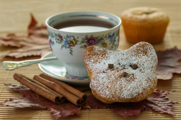 Still life with autumn leaves and a muffin that looks like a cat