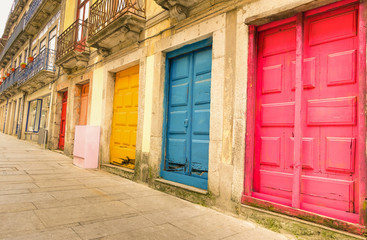 Colorful worn painted doors along street in Portugal - Artistic concept - Warm filter look