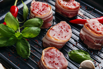 raw meat tenderloin medallions with bacon on the grill