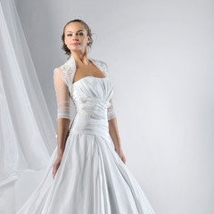 Beautiful young woman in wedding dress at studio