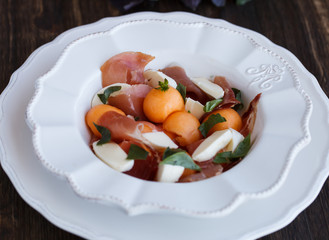 Salad melon with ham, eggs, mozzarella and Basil.selective focus