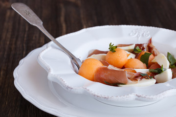 Salad melon with ham, eggs, mozzarella and Basil.selective focus