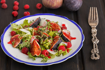 Salad with figs and raspberries, dressed with raspberry sauce and Parmesan cheese