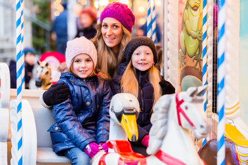 Obraz na płótnie Canvas Familie fährt Karussell auf dem Weihnachtsmarkt