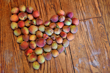 Organic peaches in heart shape agianst wood background
