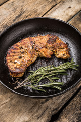 Roasted beefsteak with bunch of rosemary on grill pan
