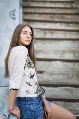 Young caucasian hipster girl relaxing on stairs in the city.
