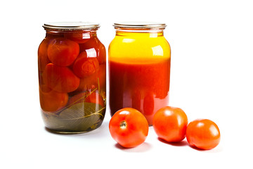 Glass jars of canned tomatoes and tomatoes juice on white backgr