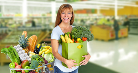 Woman with grocery bag of vegetables.