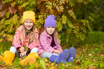 Little adorable girls at warm sunny autumn day outdoors