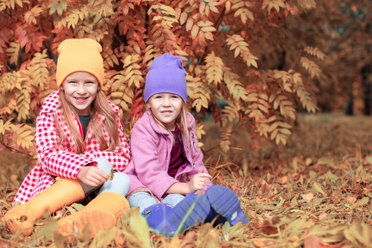 Little adorable girls at warm sunny autumn day outdoors