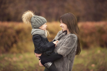 Adorable little girl with mother in autumn park outdoors