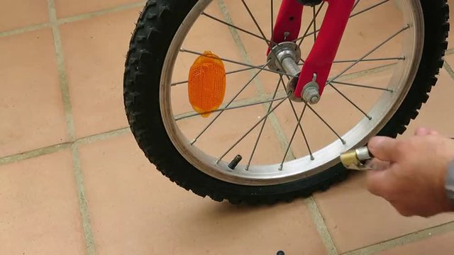 Inflado de rueda de bicicleta, con compresor de aire y manómetro.
