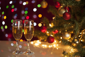 Two glasses of champagne near beautiful christmas tree 