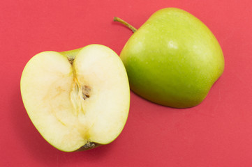Two halves of an apple on red background